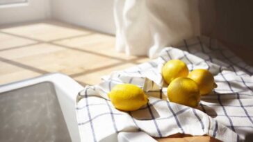 lemons on a dish cloth on the counter next to the sink