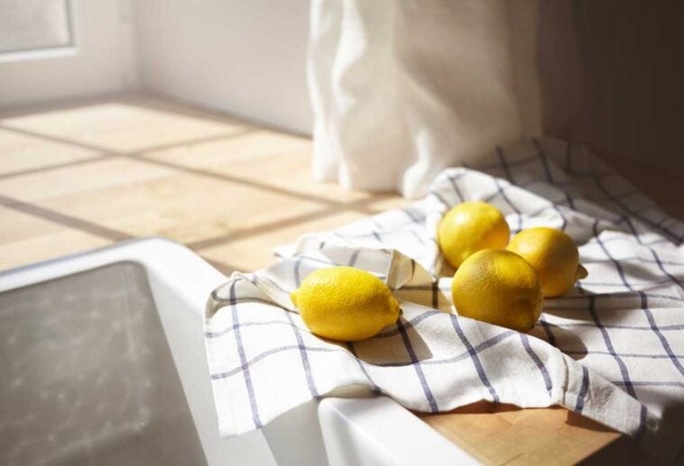 lemons on a dish cloth on the counter next to the sink