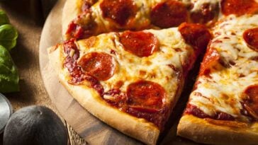 Close up of a pizza with a slice being removed