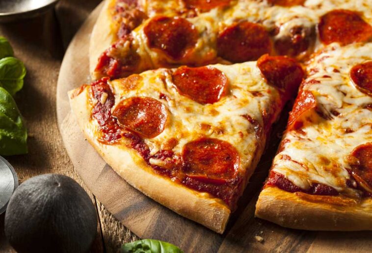 Close up of a pizza with a slice being removed