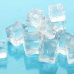 Ice cubes scattered on a teal blue background