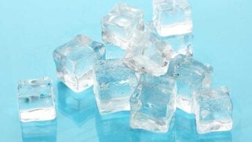 Ice cubes scattered on a teal blue background