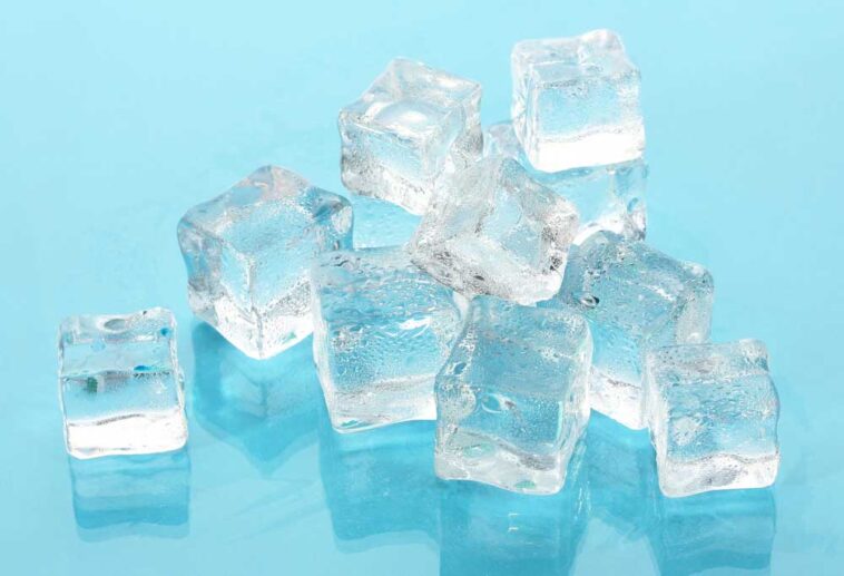 Ice cubes scattered on a teal blue background