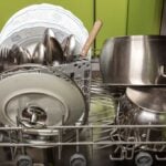 Dishes in a dishwasher with a lime green wall in the background