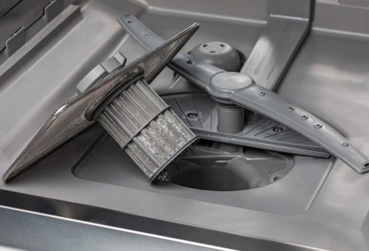 The bottom of the inside of a dishwasher, taken apart
