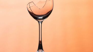 Broken wine glass on a orange background