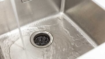 Overhead view of a sink with a garbage disposal with the sink water running