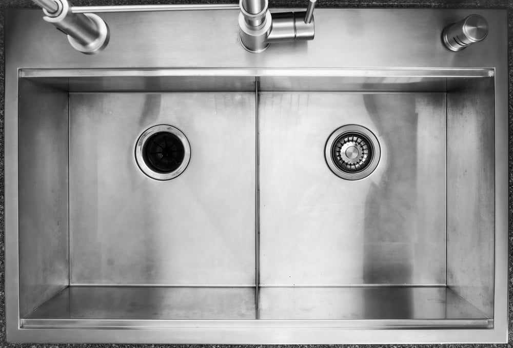 overhead view of a double sided stainless steel sink with a garbage disposal drain.