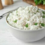 Bowl of rice with parsley sitting on a white table