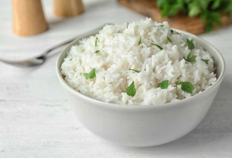 Bowl of rice with parsley sitting on a white table