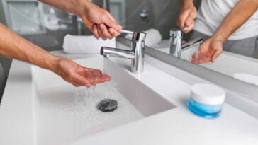 Person washing their hands at a countertop with sink- all in one-
