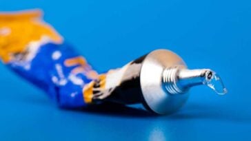 Tube of super glue on a bright blue surface