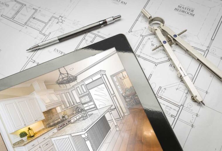 Tablet laying on top of kitchen design plans with drafting tools