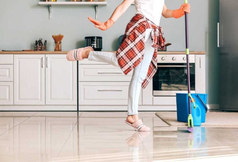 Woman in pink slippers mopping the kitchen floor