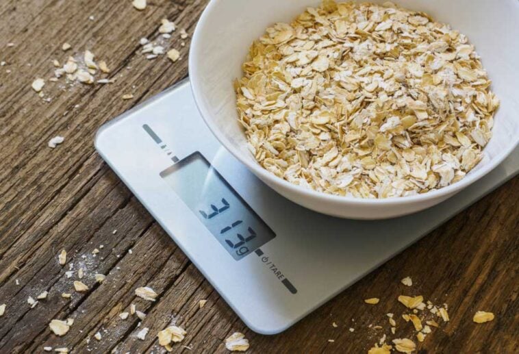 Digital kitchen scale with a bowl of oats in it being weighed